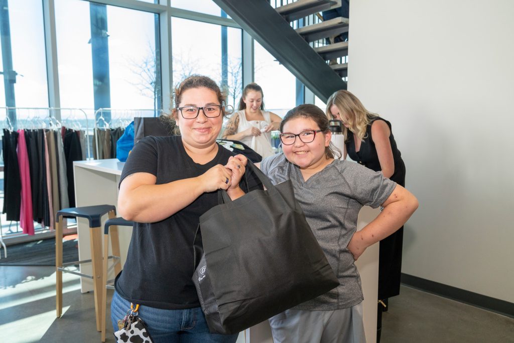 Mother and daughter pose together after shopping for clothes at Denver Housing Authority's Economic Self Sufficiency Summitt